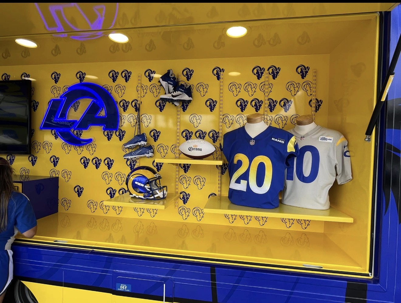 Display case with Los Angeles Rams jerseys and memorabilia.